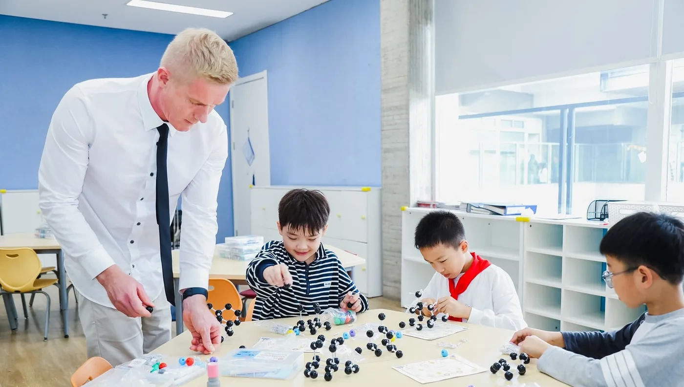 Werner Guderian working with three learners around a table of models
