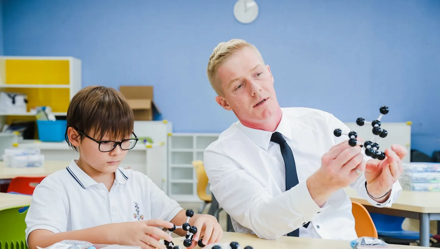 Werner Guderian and a primary learner building molecular models side by side