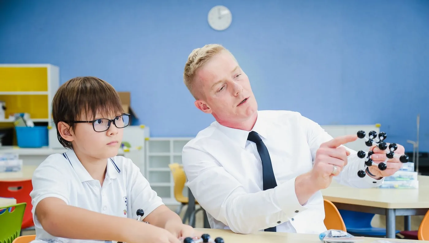 Werner Guderian explaining a molecular model to a primary learner sitting beside him